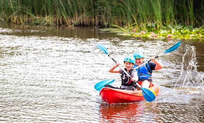 An image of a family kayaking on Bluestone's beautiful private lake.